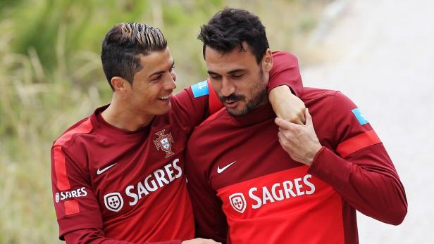 Cristiano Ronaldo umarmt einen Teamkollegen in Trainingskleidung der portugiesischen Nationalmannschaft.
