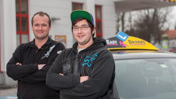 Zwei Männer stehen vor einem Fahrschulauto mit dem Schriftzug „Easy Drivers“.