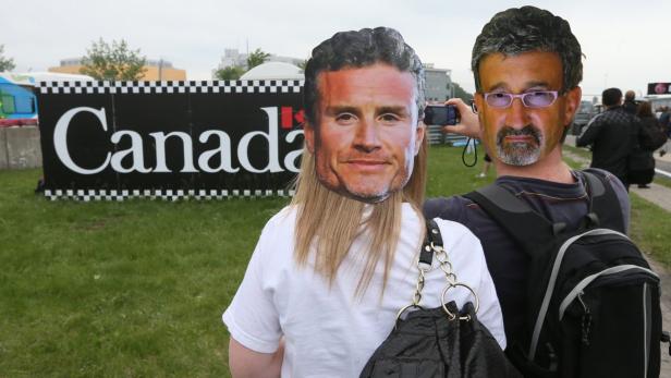 Two fans wearing masks of former race car drivers David Coulthard (L) and Eddie Jordan take a photo outside the paddocks ahead of the Canadian F1 Grand Prix at the Circuit Gilles Villeneuve in Montreal, June 6, 2013. The Canadian F1 Grand Prix will take place on June 9. REUTERS/Christinne Muschi (CANADA - Tags: SPORT MOTORSPORT F1 TPX IMAGES OF THE DAY)