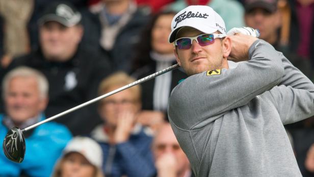 Ein Golfspieler schwingt seinen Schläger vor einer Zuschauermenge.