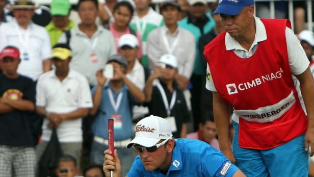 epa03687963 Bernd Wiesberger (C) of Austria and his caddy Shane Koeries (R) during the fourth round of the Indonesian Masters 2013 played at Royale Jakarta Golf Club, Jakarta, Indonesia, 05 May 2013. Wiesberger won the event with 15 under par. EPA/ADI WEDA