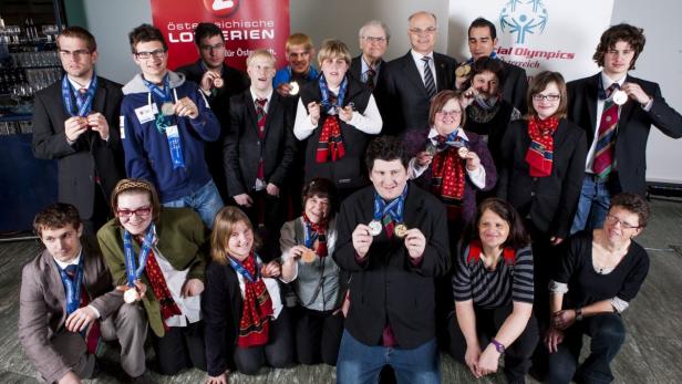 Eine Gruppe von Athleten der Special Olympics präsentiert stolz ihre Medaillen.