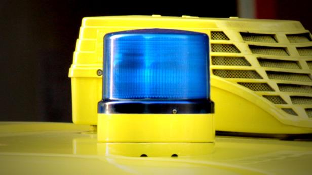Nahaufnahme eines gelben Einsatzfahrzeugs mit Blaulicht.