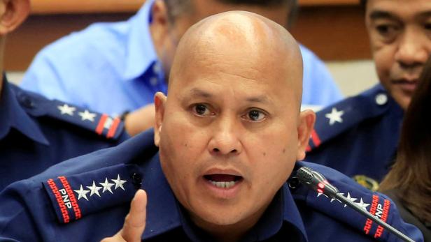 Ein Mann in Polizeiuniform spricht in ein Mikrofon.