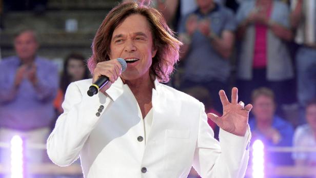 Dieter Bohlen singt in einem weißen Anzug vor Publikum.