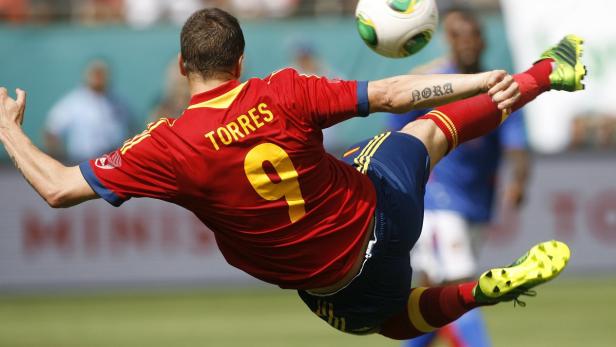 Der Fußballspieler Fernando Torres springt, um den Ball zu treten.