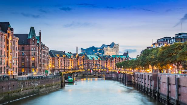 Die Speicherstadt und die Elbphilharmonie in Hamburg bei Dämmerung.
