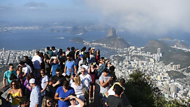 Eine Menschenmenge blickt auf Rio de Janeiro mit dem Zuckerhut im Hintergrund.