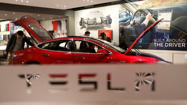 FILE PHOTO: A man looks around Tesla Motors' Model S P85 at its showroom in Beijing