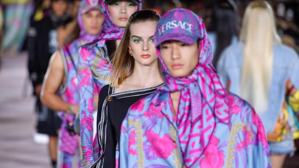 Models präsentieren Mode von Versace auf dem Laufsteg.