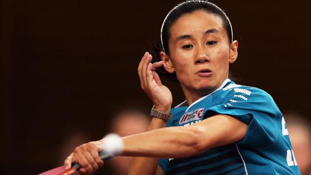 Eine Tischtennisspielerin beim Aufschlag.