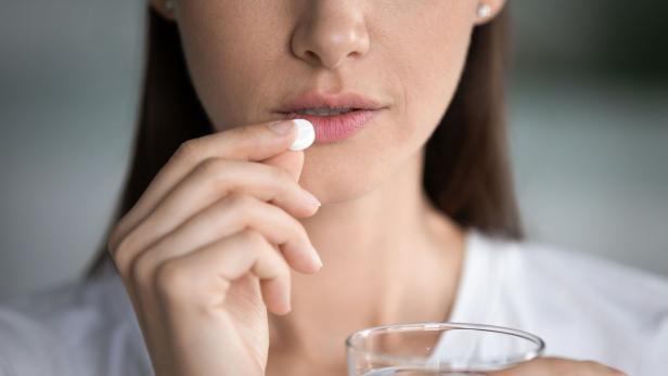 Junge Frau nimmt Tablette ein