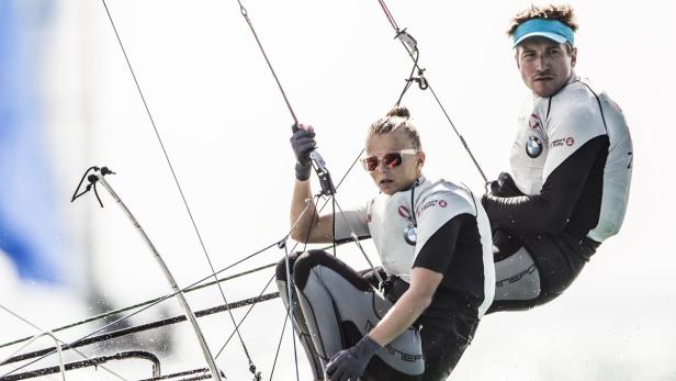 Zwei Segler arbeiten zusammen auf einem Segelboot.