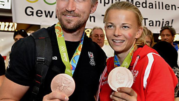 Zwei österreichische Sportler präsentieren stolz ihre Bronzemedaillen.