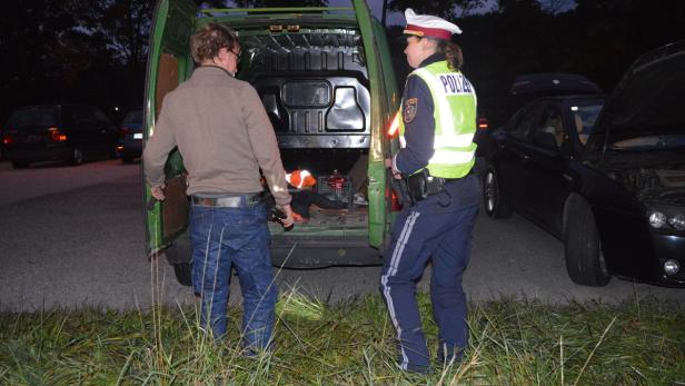 Eine Polizistin kontrolliert den Laderaum eines ungarischen Pkw