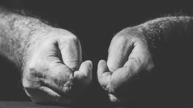 Zwei menschliche Hände liegen auf einer Oberfläche.