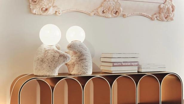 Zwei Teddybär-Lampen stehen auf einem Tisch unter einem gerahmten Bild mit Strichzeichnungen.