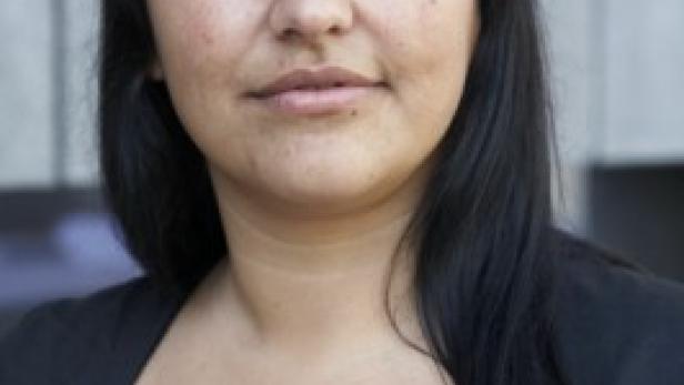 Porträt einer Frau mit dunklen Haaren und einem schwarzen Oberteil.