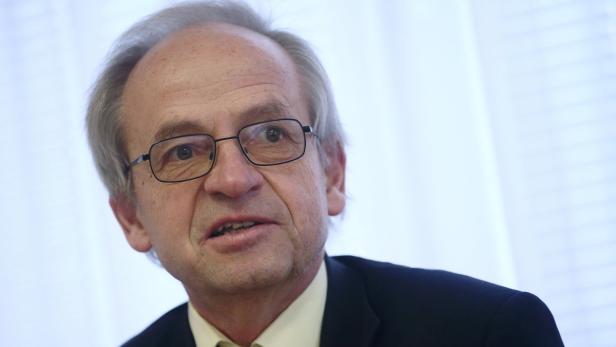 Ein Mann mit Brille und Anzug spricht.