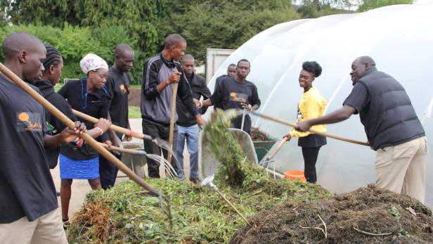 Mit viel Eifer legen junge Kenianer eine Kompostmiete an