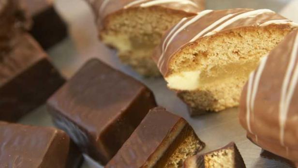 Verschiedene Schokoladen- und Cremeschnitten liegen auf einer Platte.