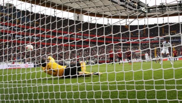 Ein Fußballtorwart versucht, einen Ball während eines Spiels zu halten.