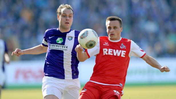 Zwei Fußballspieler kämpfen um den Ball.