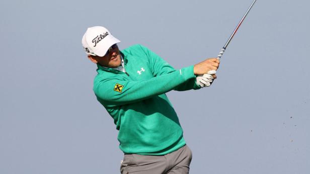 Ein Golfspieler schwingt seinen Schläger vor einem hellen Himmel.