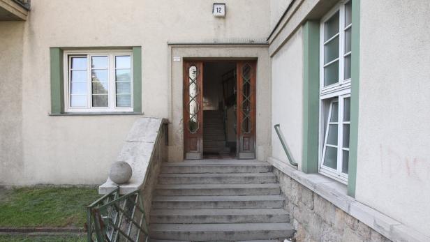 Treppe führt zu einer offenen Haustür mit der Nummer 12.