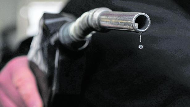 Gasoline drips out of a nozzle held by a gas station mechanic in Somerville