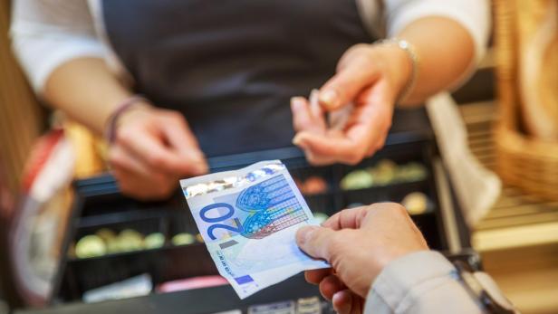 woman is paying In cash with euro banknotes
