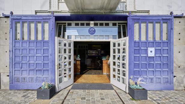 Der Eingang zum Restaurant „Lieb & Fisch“ mit blauen Schiebetüren und geöffneten weißen Fenstertüren.