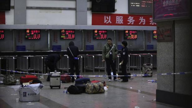 Ein abgesperrter Bereich in einem Bahnhof mit Gepäck und Personen.