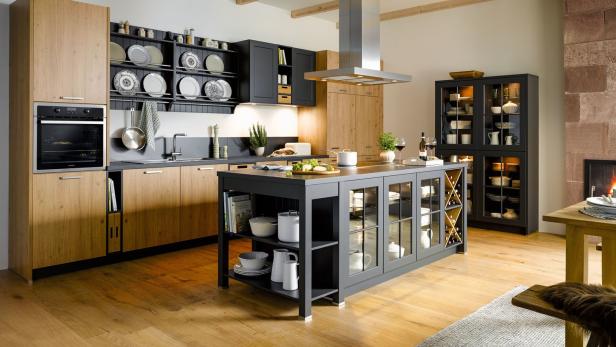 Eine moderne Küche mit Kochinsel, Holzboden und sichtbaren Holzbalken an der Decke.