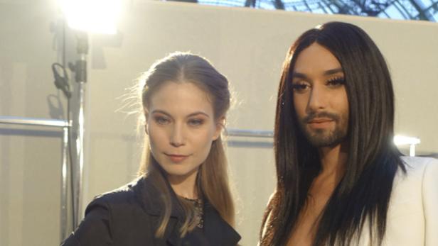 Eine Frau und Conchita Wurst posieren für ein Foto.