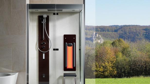 Eine moderne Duschkabine mit Infrarotpaneel und Blick auf eine Landschaft mit Burgruine.