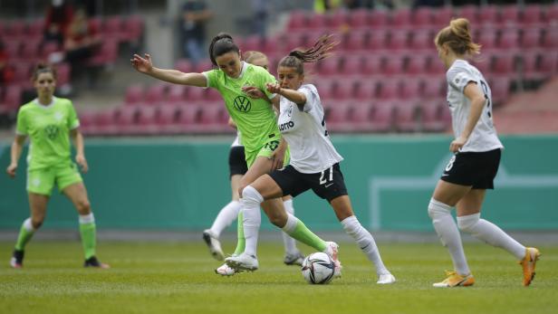 Zwei Fußballspielerinnen kämpfen um den Ball während eines Spiels.