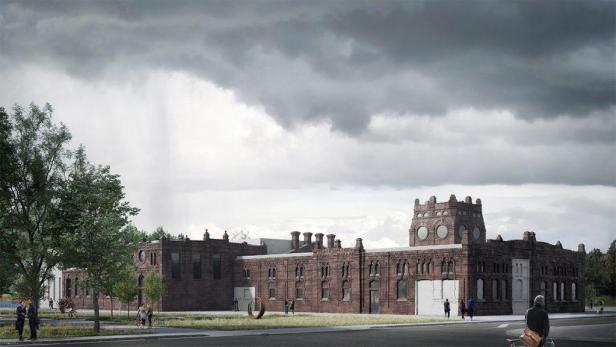 Ein großes Backsteingebäude mit einem Turm unter einem bewölkten Himmel.
