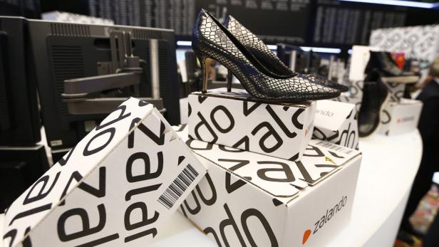 Ein Paar Damenschuhe mit Schlangenmuster stehen auf Zalando-Kartons.
