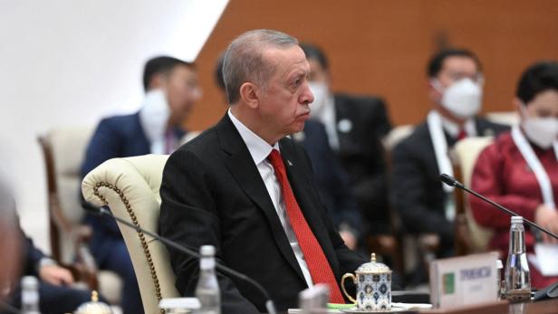 Recep Tayyip Erdoğan sitzt während einer Konferenz an einem Tisch.