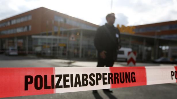 Ein rot-weißes Polizeiabsperrband vor einem Gebäude.