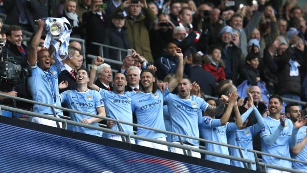 Manchester City feiert den Gewinn eines Pokals mit den Fans.