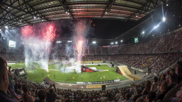 Ein Stadion ist mit Zuschauern gefüllt, während Feuerwerk auf dem Feld gezündet wird.