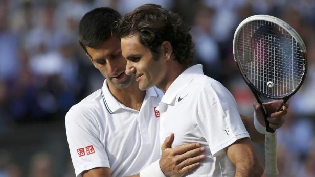 Roger Federer und Novak Djokovic umarmen sich auf einem Tennisplatz.