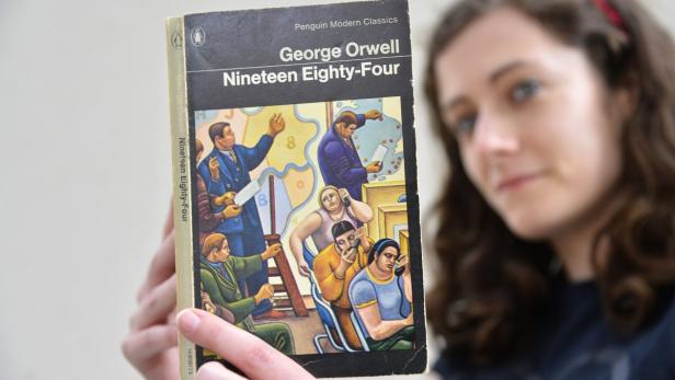 Laura Wood of Skoob Books poses for a photograph with a copy of George Orwell&#039;s &#039;1984&#039; in central London June 9, 2013. The novel, which is set in a world of government surveillance, was first published by Secker and Warburg 64 years ago on June 8, 1949. REUTERS/Toby Melville (BRITAIN - Tags: POLITICS SOCIETY)
