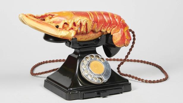 Ein schwarzes Wählscheibentelefon mit einem Hummer als Hörer.