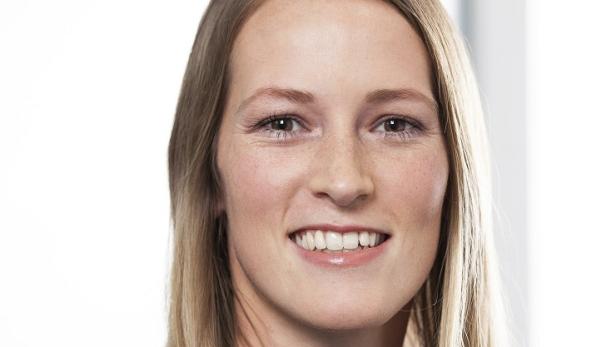 Porträt einer lächelnden Frau mit blonden Haaren.