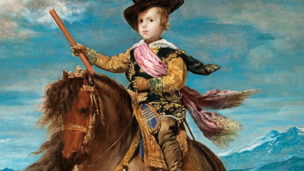 Ein junger Prinz reitet auf einem Pferd vor einer Bergkulisse.