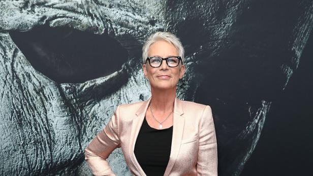 Jamie Lee Curtis posiert vor einem Poster für den Film „Halloween“.