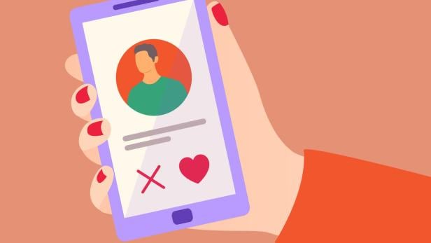 Eine Hand hält ein Smartphone mit einer Dating-App, auf der ein Mann abgebildet ist.
